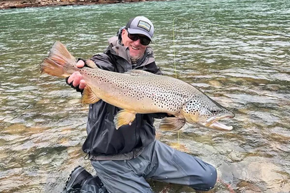 A River of Dreams guest with a massive brown trout